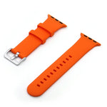 Silver buckle silicone replacement watch strap in vibrant orange color, compatible with Apple Watch series.