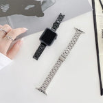 Three-beads steel replacement watchband for Apple Watch displayed next to a black watchband on a table.