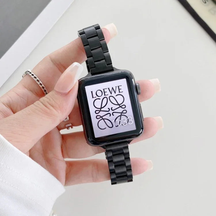 steel replacement watchband for Apple Watch on a wrist, displaying a stylish black strap with a screen showing LOEWE logo.